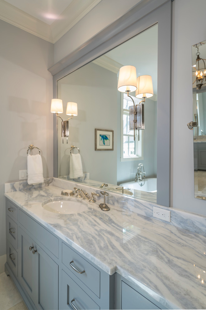 This is an example of a large contemporary ensuite bathroom in Atlanta with shaker cabinets, grey cabinets, a freestanding bath, a two-piece toilet, grey walls, ceramic flooring, a submerged sink and engineered stone worktops.