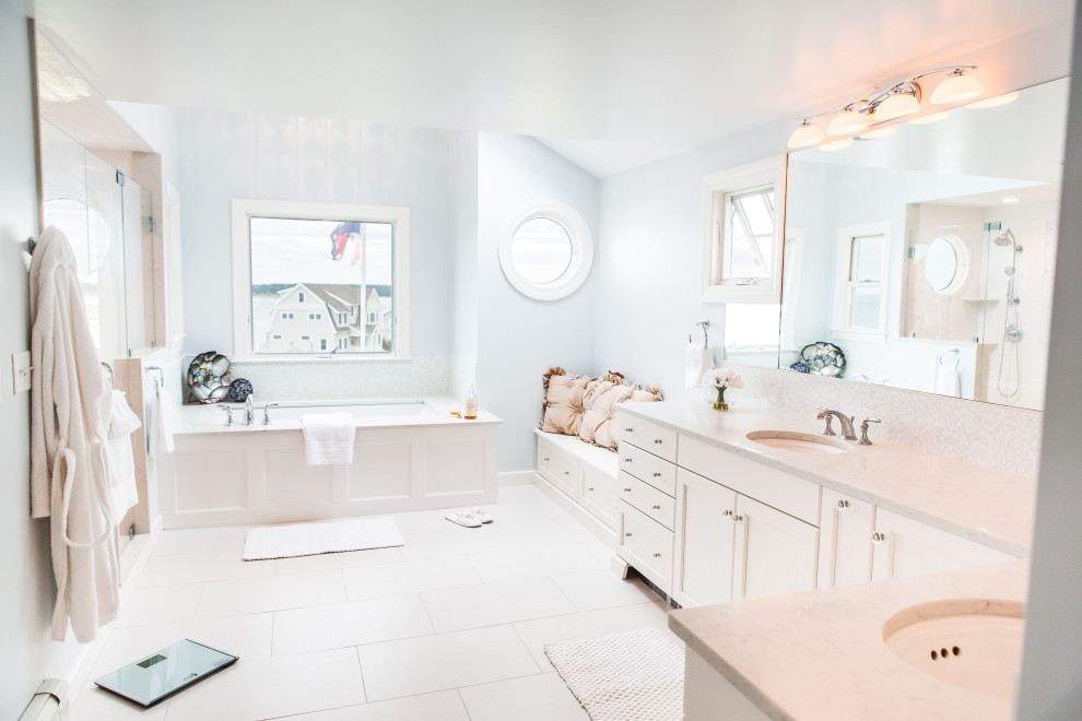 На фото: большая главная ванная комната в морском стиле с фасадами в стиле шейкер, белыми фасадами, накладной ванной, душем без бортиков, раздельным унитазом, белой плиткой, керамической плиткой, синими стенами, полом из керамогранита, врезной раковиной, столешницей из искусственного кварца, серым полом, душем с распашными дверями, белой столешницей, нишей, тумбой под две раковины и встроенной тумбой с
