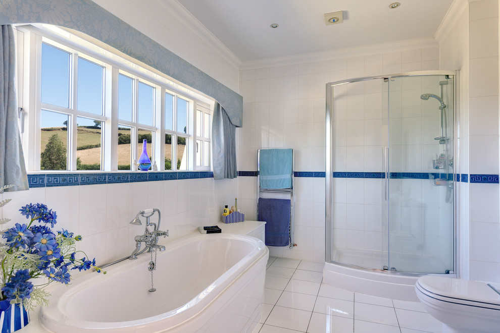 This is an example of a country bathroom in Devon with a built-in bath and blue tiles.