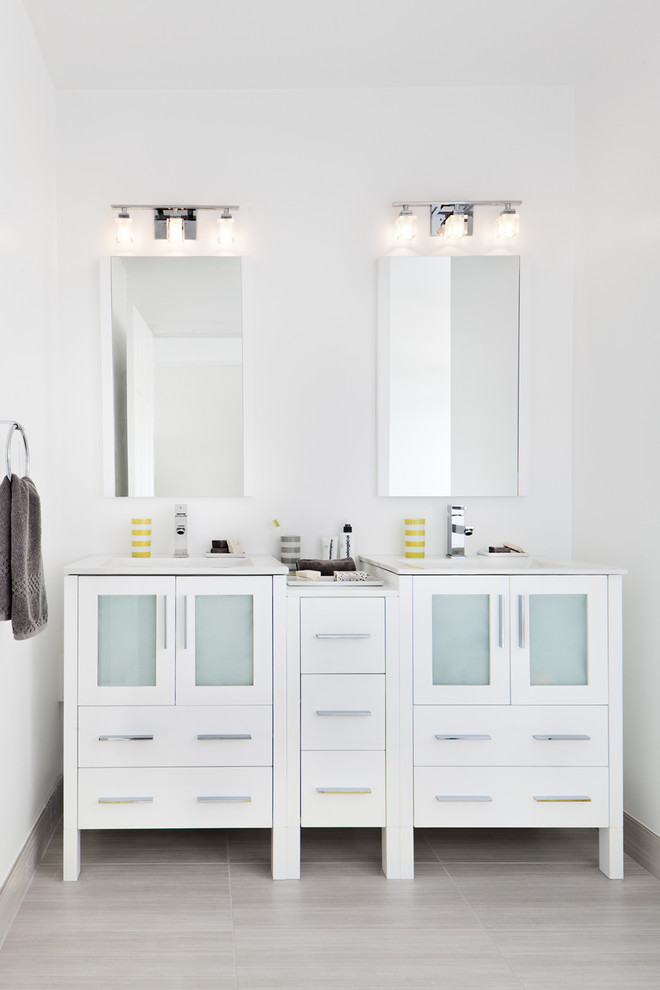 Cette photo montre une salle de bain tendance de taille moyenne avec des portes de placard blanches, un lavabo intégré, un mur blanc, un sol en carrelage de porcelaine, un plan de toilette blanc et un placard à porte vitrée.