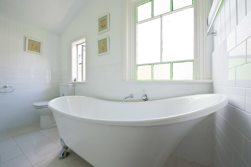 Пример оригинального дизайна: ванная комната среднего размера в викторианском стиле с плоскими фасадами, белыми фасадами, отдельно стоящей ванной, угловым душем, раздельным унитазом, белой плиткой, плиткой кабанчик, белыми стенами, настольной раковиной и душем с распашными дверями