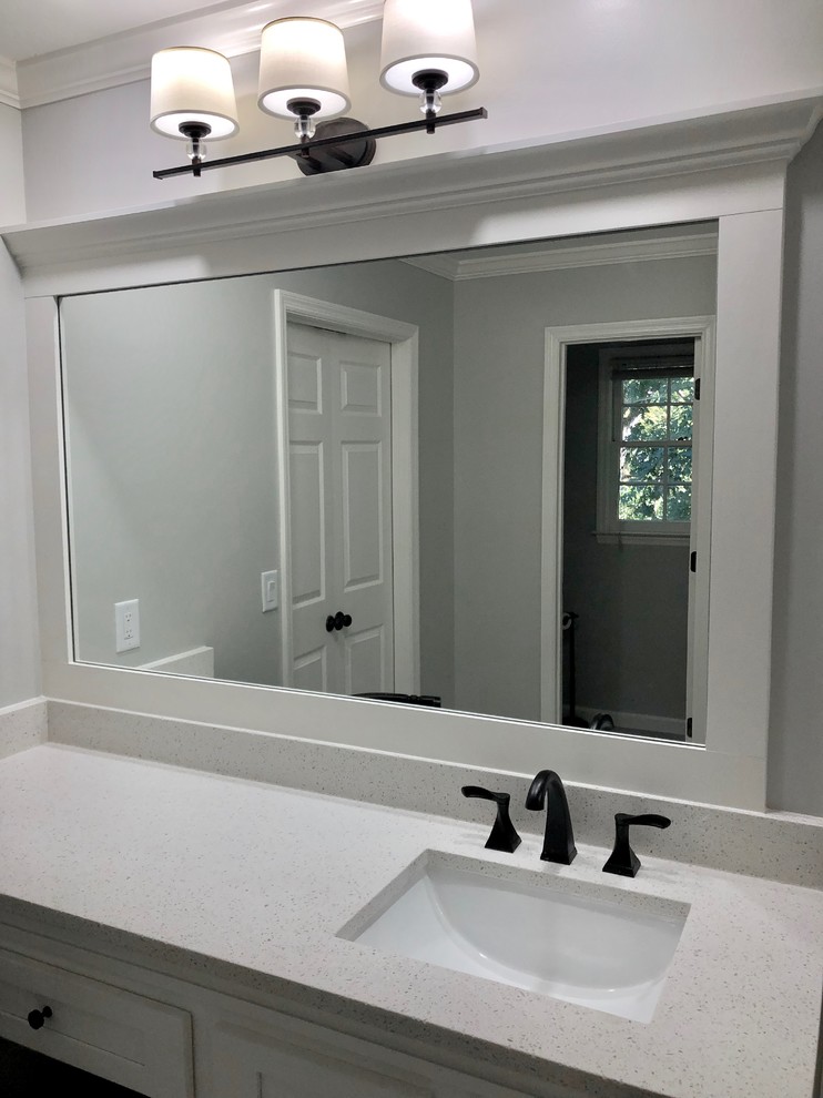 Photo of a large classic ensuite bathroom in Atlanta with shaker cabinets, white cabinets, a freestanding bath, a corner shower, a two-piece toilet, grey tiles, ceramic tiles, grey walls, ceramic flooring, a submerged sink, engineered stone worktops, grey floors, a hinged door and white worktops.