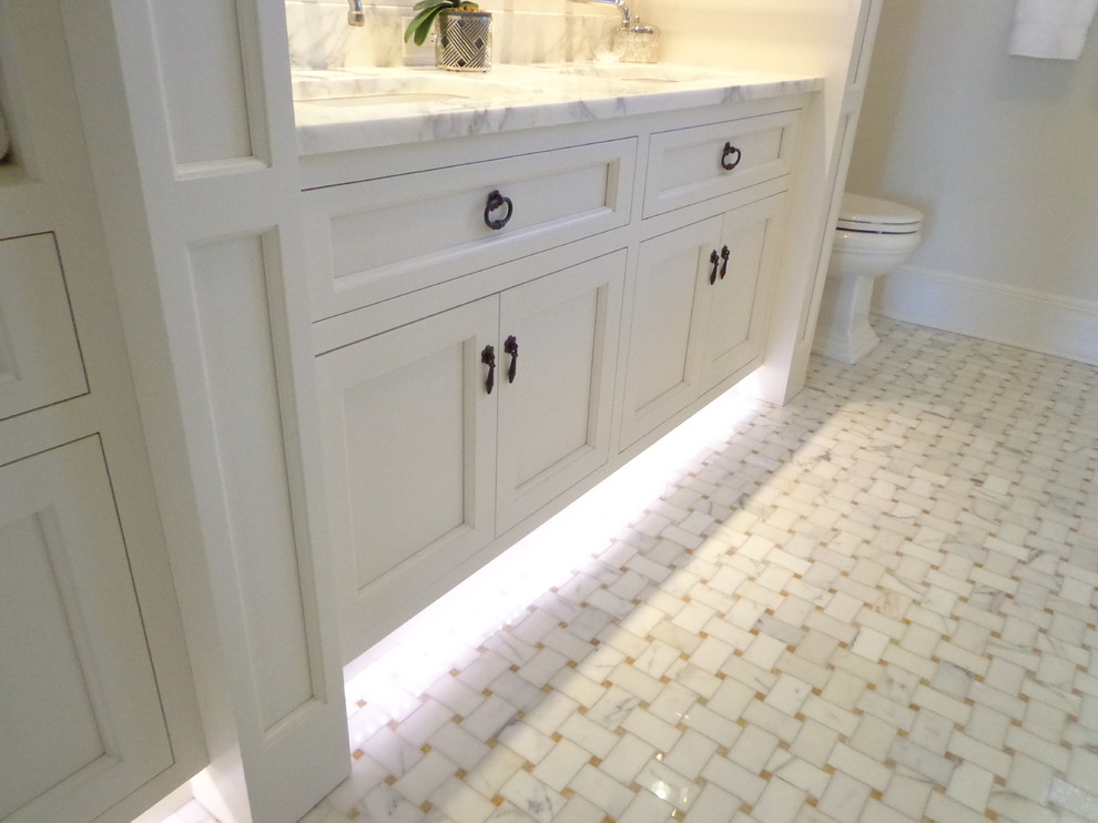На фото: большая главная ванная комната в классическом стиле с фасадами в стиле шейкер, белыми фасадами, ванной в нише, угловым душем, раздельным унитазом, белыми стенами, полом из линолеума, врезной раковиной и мраморной столешницей