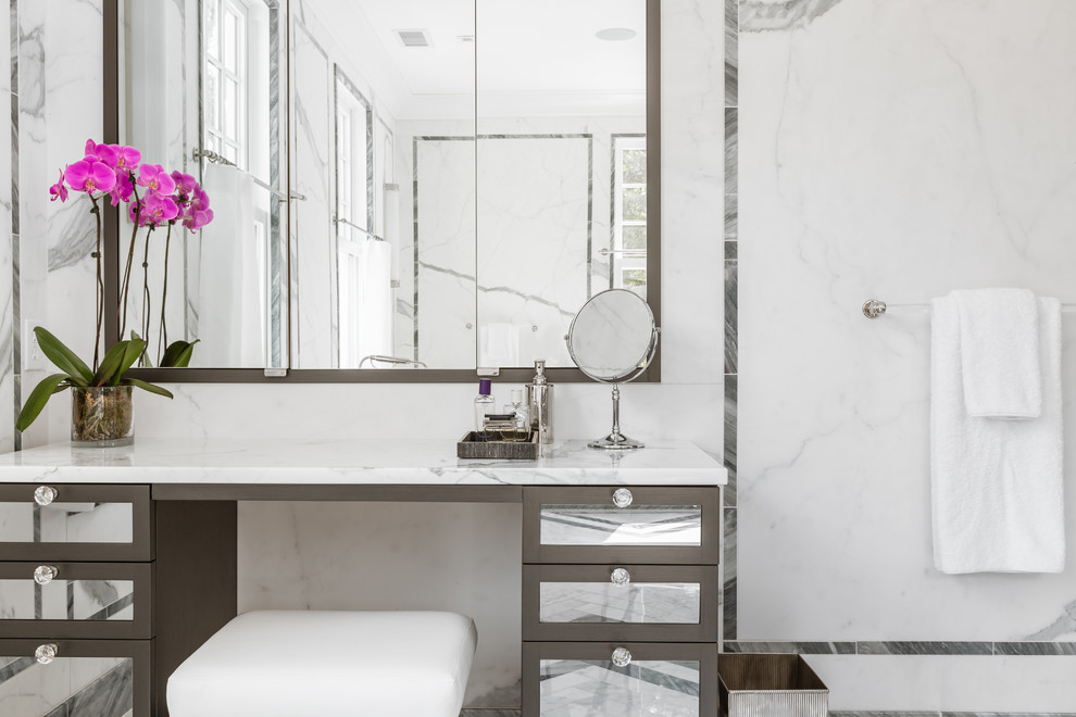 Cette image montre une salle de bain principale traditionnelle avec un lavabo encastré, un placard en trompe-l'oeil, un plan de toilette en marbre, une baignoire indépendante, une douche double, un carrelage gris, un carrelage de pierre et un sol en marbre.
