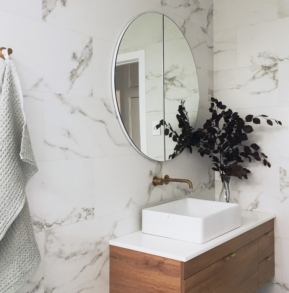Пример оригинального дизайна: маленькая главная ванная комната в современном стиле с накладной ванной, душевой комнатой, белой плиткой, белыми стенами, полом из керамической плитки, настольной раковиной, белым полом, белой столешницей, светлыми деревянными фасадами, инсталляцией, керамической плиткой, открытым душем, акцентной стеной, нишей, окном, тумбой под одну раковину и подвесной тумбой для на участке и в саду