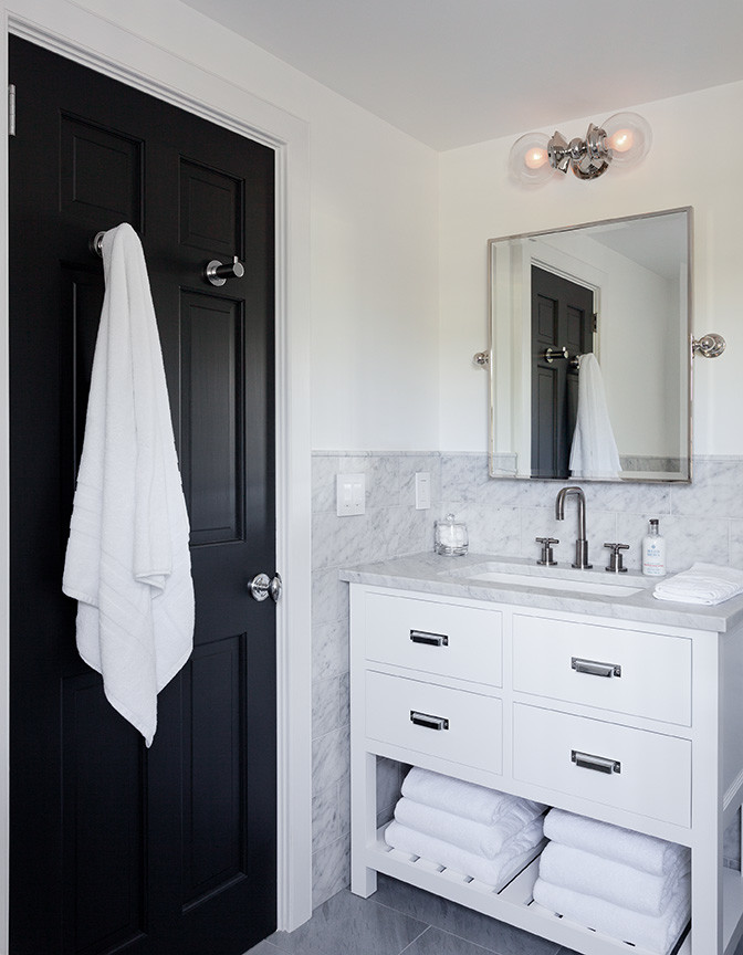 This is an example of a small nautical shower room bathroom in New York with open cabinets, white cabinets, a walk-in shower, a one-piece toilet, grey tiles, stone tiles, white walls, marble flooring, a wall-mounted sink and wooden worktops.