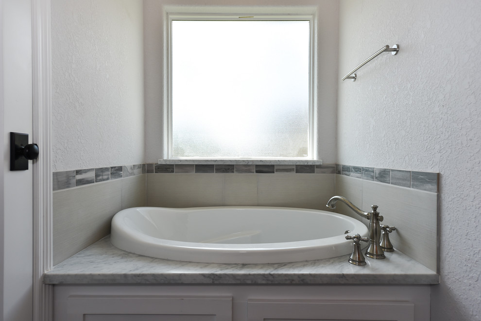 Пример оригинального дизайна: большая главная ванная комната в стиле модернизм с фасадами в стиле шейкер, белыми фасадами, накладной ванной, открытым душем, унитазом-моноблоком, серой плиткой, керамической плиткой, серыми стенами, полом из винила, врезной раковиной и столешницей из гранита