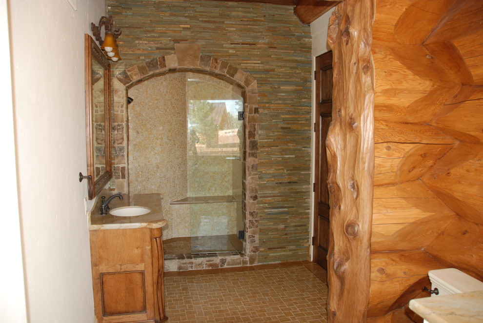 Aménagement d'une grande salle d'eau montagne en bois brun avec un lavabo encastré, un placard en trompe-l'oeil, un plan de toilette en marbre, une douche ouverte, WC séparés, un mur blanc, une baignoire posée et un carrelage jaune.