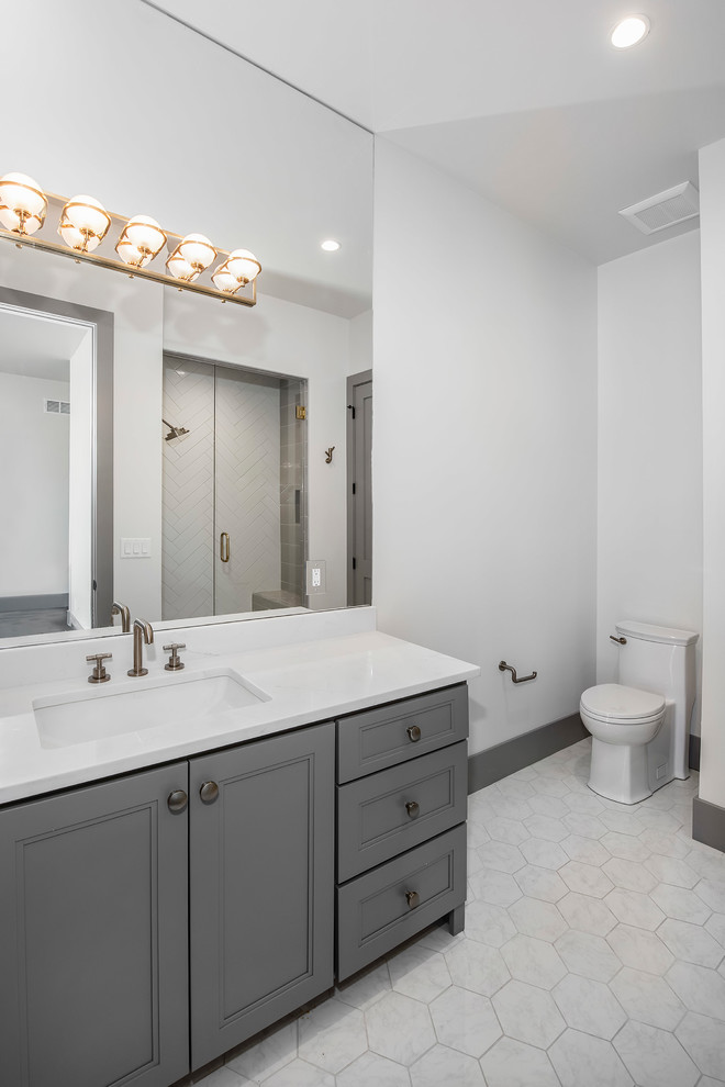Imagen de cuarto de baño principal actual de tamaño medio con puertas de armario grises, paredes blancas y encimeras blancas