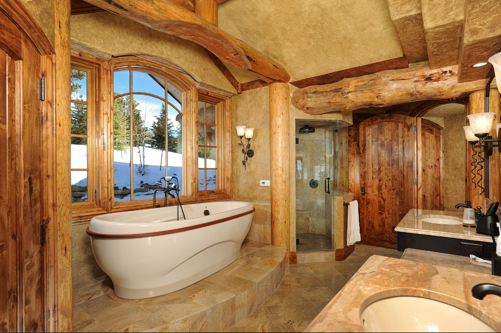 Rustik inredning av ett stort en-suite badrum, med ett undermonterad handfat, skåp i mörkt trä, ett fristående badkar, en hörndusch, beige kakel, beige väggar, keramikplattor, klinkergolv i keramik och marmorbänkskiva