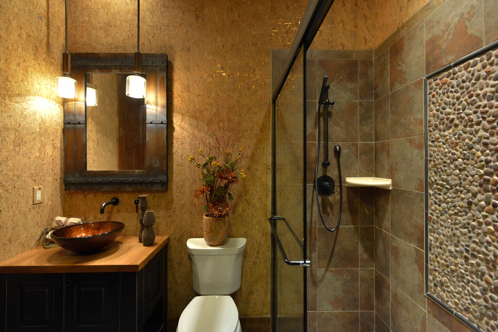 Design ideas for a medium sized rustic shower room bathroom in Denver with raised-panel cabinets, black cabinets, an alcove shower, a two-piece toilet, multi-coloured walls, ceramic flooring, a vessel sink and wooden worktops.