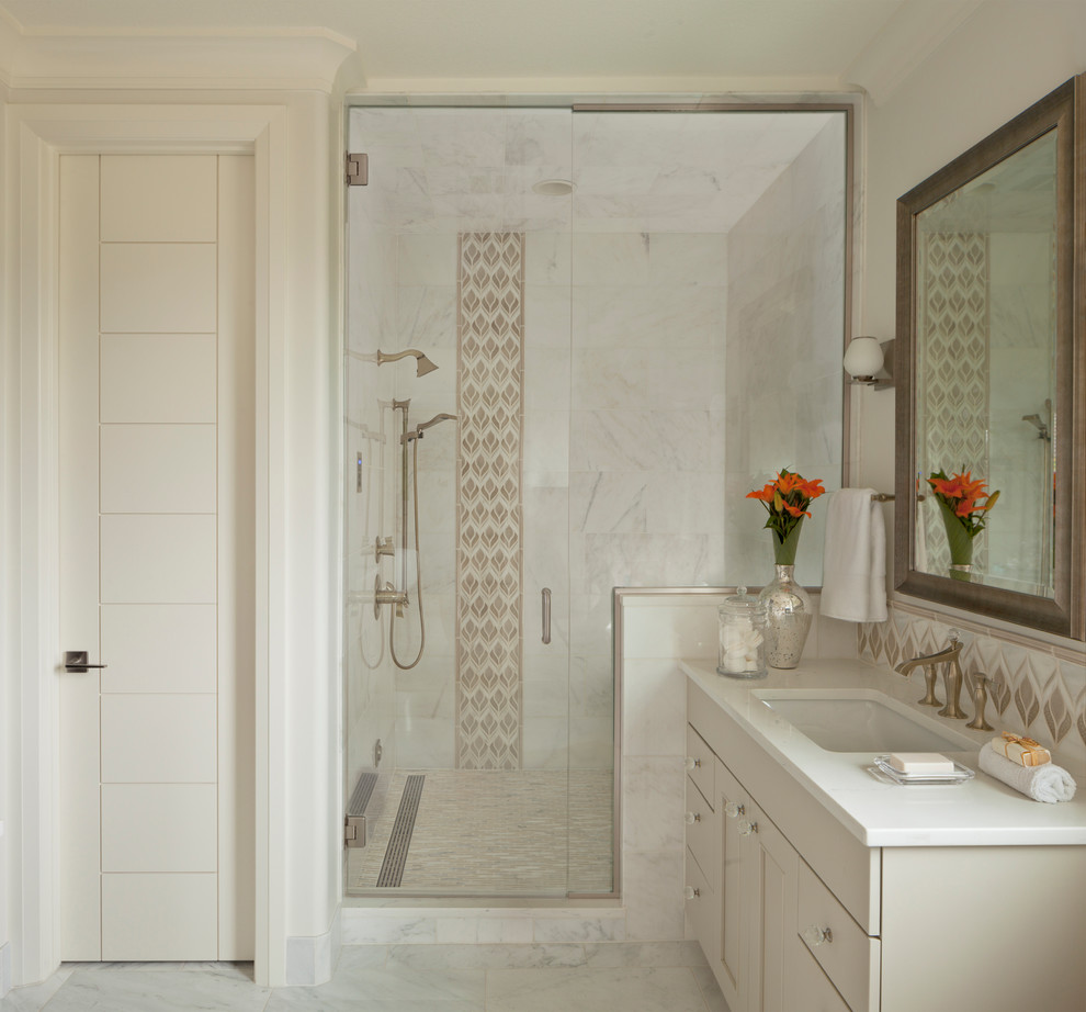 Klassisches Duschbad mit Schrankfronten im Shaker-Stil, beigen Schränken, Duschnische, weißer Wandfarbe, Marmorboden, Unterbauwaschbecken und Falttür-Duschabtrennung in Denver