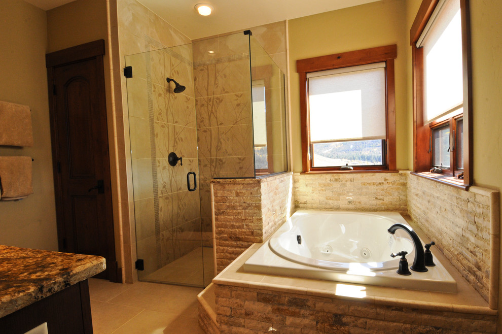 Cette photo montre une grande salle de bain principale montagne avec des portes de placard marrons, une baignoire posée, WC à poser, un mur noir, sol en béton ciré, un plan de toilette en granite et un sol beige.