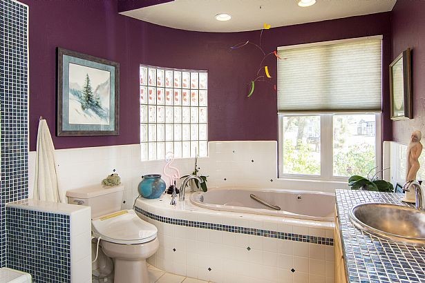 Inspiration for a mid-sized contemporary master multicolored tile and glass sheet ceramic tile doorless shower remodel in Los Angeles with glass-front cabinets, light wood cabinets, a hot tub, a two-piece toilet, purple walls, glass countertops and a drop-in sink