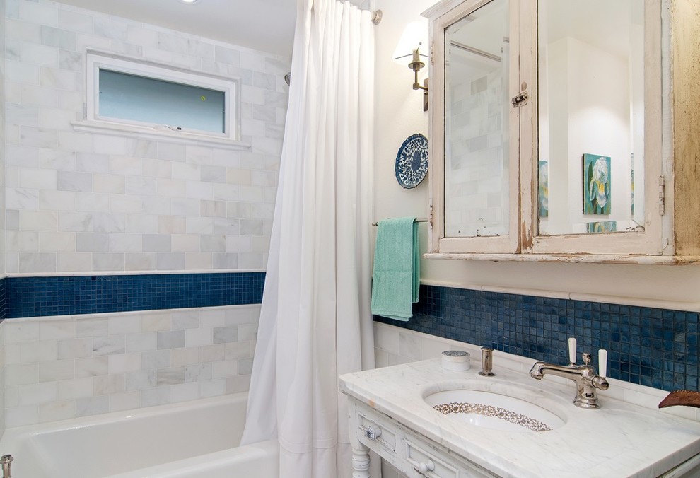 Small beach style 3/4 white tile and stone tile mosaic tile floor bathroom photo in San Diego with furniture-like cabinets, distressed cabinets, white walls, an undermount sink, marble countertops and a two-piece toilet