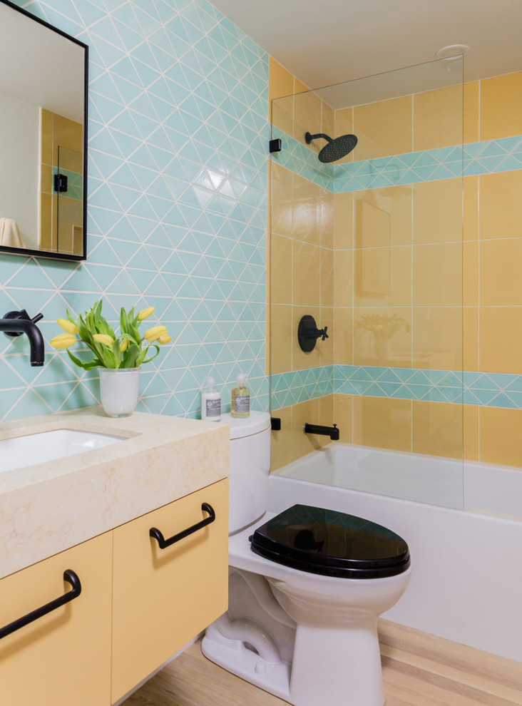 Свежая идея для дизайна: маленькая детская ванная комната в современном стиле с желтыми фасадами, душем над ванной, разноцветной плиткой, керамической плиткой, синими стенами, светлым паркетным полом, бежевым полом, открытым душем и желтой столешницей для на участке и в саду - отличное фото интерьера