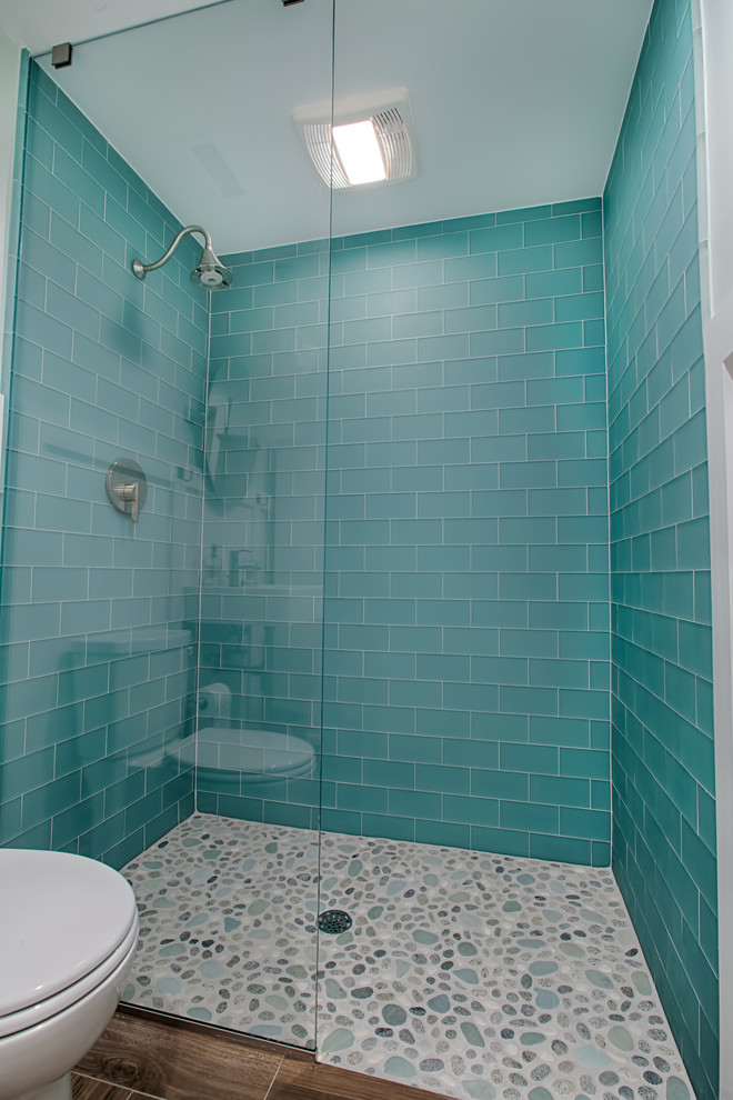 Esempio di una stanza da bagno stile marino di medie dimensioni con ante bianche, piastrelle blu, piastrelle di vetro, pavimento con piastrelle in ceramica, lavabo sospeso, pavimento marrone e doccia aperta