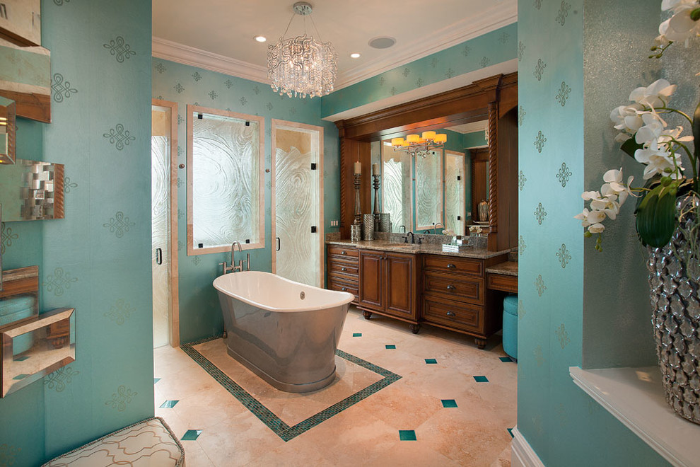 Idéer för att renovera ett stort tropiskt en-suite badrum, med luckor med upphöjd panel, ett fristående badkar, våtrum, en toalettstol med hel cisternkåpa, blå kakel, travertinkakel, blå väggar, travertin golv, ett nedsänkt handfat, granitbänkskiva, beiget golv och dusch med gångjärnsdörr