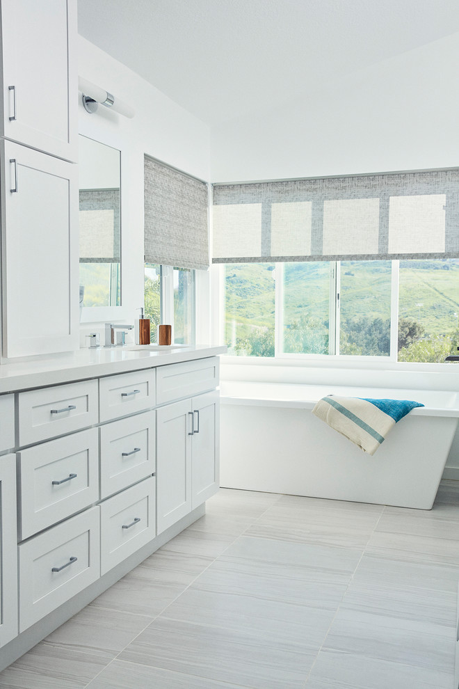 Idéer för att renovera ett funkis en-suite badrum, med skåp i shakerstil, vita skåp, ett fristående badkar, en hörndusch, vita väggar, klinkergolv i porslin, bänkskiva i kvartsit och grått golv