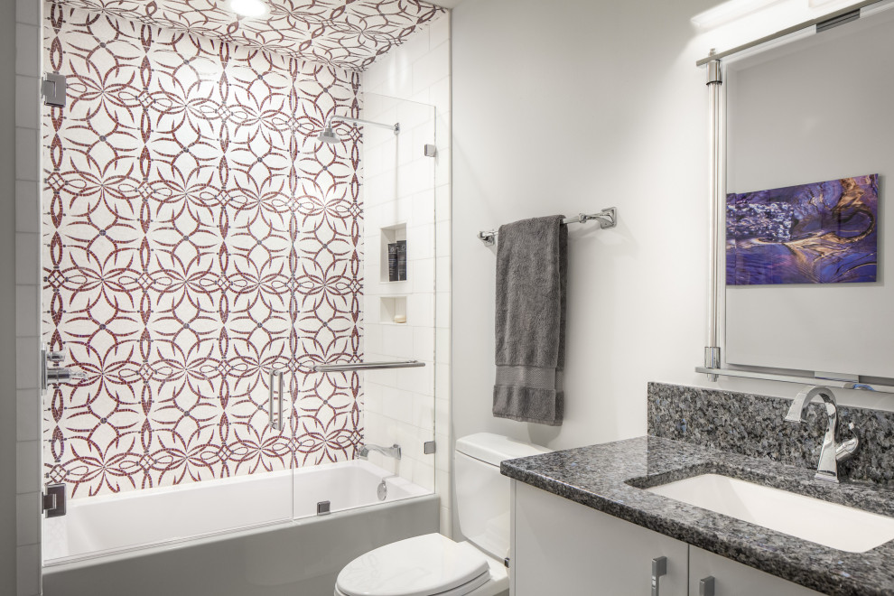 Пример оригинального дизайна: детская ванная комната среднего размера в стиле неоклассика (современная классика) с плоскими фасадами, белыми фасадами, накладной ванной, душем над ванной, унитазом-моноблоком, плиткой мозаикой, белыми стенами, полом из керамической плитки, врезной раковиной, столешницей из гранита, белым полом, душем с распашными дверями, синей столешницей, тумбой под одну раковину и встроенной тумбой