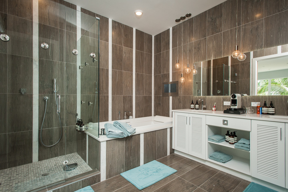 Large beach style ensuite bathroom in Tampa with louvered cabinets, white cabinets, a built-in bath, a corner shower, a one-piece toilet, brown tiles, porcelain tiles, brown walls, porcelain flooring, a built-in sink, brown floors and a hinged door.
