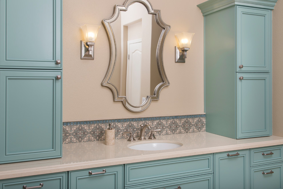 Пример оригинального дизайна: большая главная ванная комната в средиземноморском стиле с фасадами с утопленной филенкой, синими фасадами, отдельно стоящей ванной, синей плиткой, керамогранитной плиткой, столешницей из искусственного кварца, угловым душем, унитазом-моноблоком, бежевыми стенами, полом из керамогранита и врезной раковиной