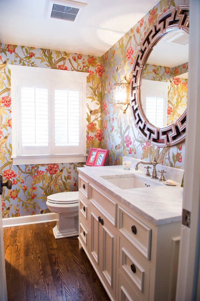 Exempel på ett mellanstort klassiskt badrum med dusch, med marmorbänkskiva, luckor med profilerade fronter, gula skåp, en toalettstol med separat cisternkåpa, flerfärgade väggar, mörkt trägolv, ett undermonterad handfat och brunt golv