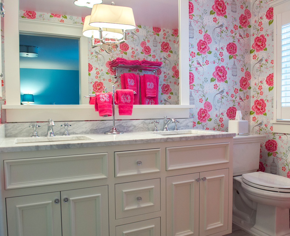 Bild på ett mellanstort vintage badrum för barn, med ett undermonterad handfat, möbel-liknande, vita skåp, marmorbänkskiva, en hörndusch, grå kakel, tunnelbanekakel, rosa väggar, klinkergolv i keramik, en toalettstol med separat cisternkåpa, brunt golv och dusch med gångjärnsdörr