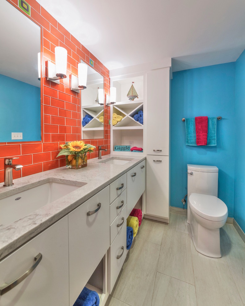他の地域にある高級な中くらいなトランジショナルスタイルのおしゃれな子供用バスルーム (フラットパネル扉のキャビネット、白いキャビネット、アルコーブ型シャワー、分離型トイレ、オレンジのタイル、ガラスタイル、青い壁、磁器タイルの床、アンダーカウンター洗面器、クオーツストーンの洗面台、ベージュの床、開き戸のシャワー) の写真