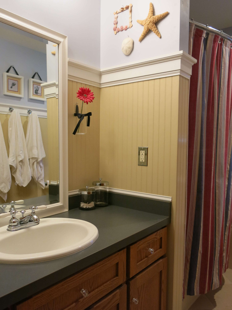 Foto på ett blå badrum med dusch, med släta luckor, skåp i mellenmörkt trä, ett badkar i en alkov, en dusch/badkar-kombination, en toalettstol med hel cisternkåpa, vit kakel, keramikplattor, klinkergolv i keramik, ett nedsänkt handfat, laminatbänkskiva, beiget golv och dusch med duschdraperi