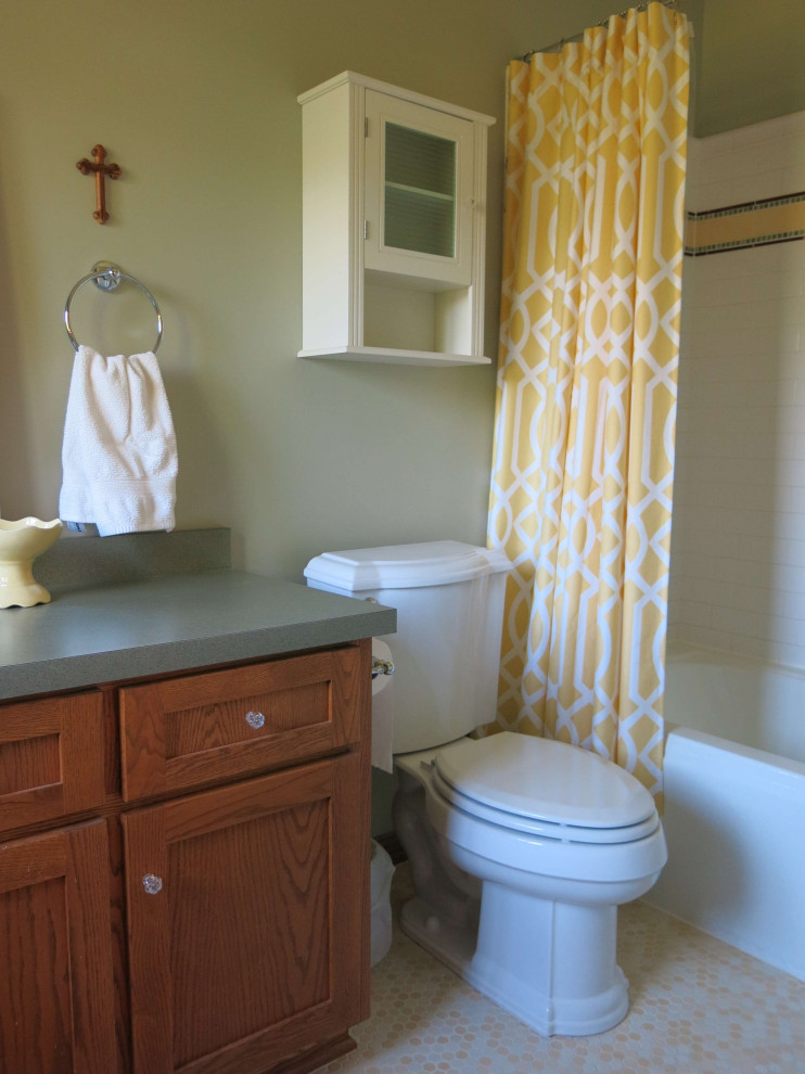 На фото: ванная комната с плоскими фасадами, фасадами цвета дерева среднего тона, ванной в нише, душем над ванной, унитазом-моноблоком, белой плиткой, керамической плиткой, зелеными стенами, полом из керамической плитки, накладной раковиной, столешницей из ламината, желтым полом, шторкой для ванной, зеленой столешницей, тумбой под одну раковину и встроенной тумбой