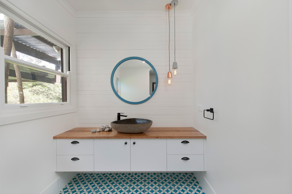 Foto di una stanza da bagno minimal con ante lisce, ante bianche, piastrelle blu, piastrelle bianche, pareti bianche e lavabo a bacinella