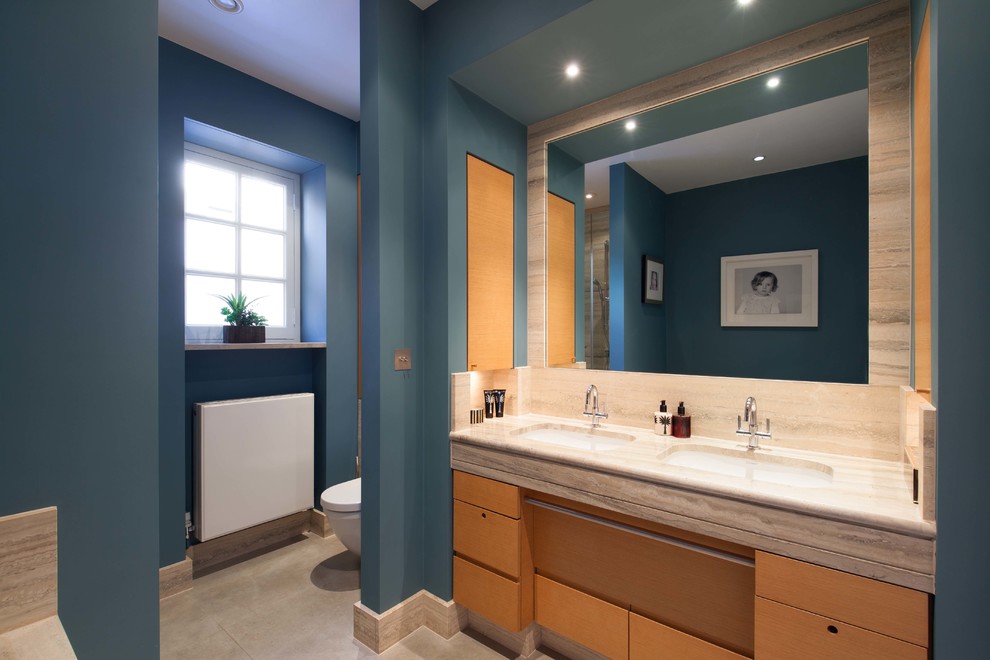 На фото: главная ванная комната среднего размера в стиле модернизм с фасадами с утопленной филенкой, светлыми деревянными фасадами, накладной ванной, душем без бортиков, инсталляцией, серой плиткой, мраморной плиткой, синими стенами, полом из сланца, монолитной раковиной, мраморной столешницей, серым полом, душем с распашными дверями и серой столешницей