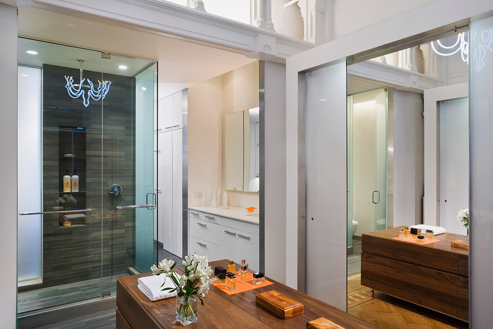 Foto di una stanza da bagno contemporanea con ante lisce, ante bianche, doccia ad angolo e piastrelle grigie