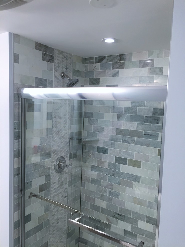 Design ideas for a medium sized modern ensuite bathroom in Baltimore with an alcove shower, grey tiles, stone tiles, grey walls, a corner bath, a one-piece toilet and a built-in sink.