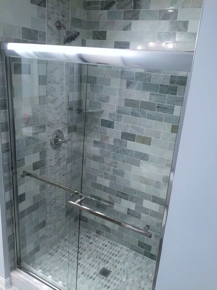 Photo of a medium sized modern ensuite bathroom in Baltimore with an alcove shower, grey tiles, stone tiles, grey walls, raised-panel cabinets, white cabinets, a corner bath, a one-piece toilet, ceramic flooring, a built-in sink and soapstone worktops.