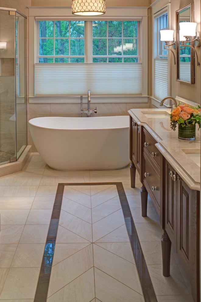 Large transitional master beige tile and porcelain tile porcelain tile and beige floor bathroom photo in Baltimore with recessed-panel cabinets, dark wood cabinets, a two-piece toilet, beige walls, an undermount sink, marble countertops, a hinged shower door and beige countertops