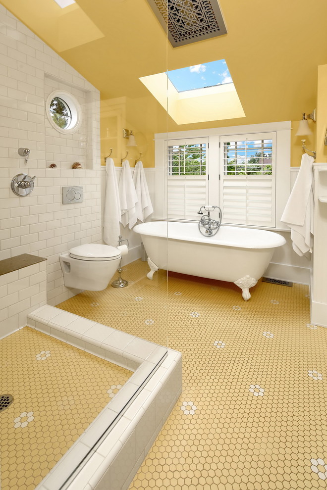 Идея дизайна: главная ванная комната среднего размера в викторианском стиле с белыми фасадами, ванной на ножках, открытым душем, инсталляцией, белой плиткой, плиткой кабанчик, желтыми стенами, полом из фанеры, разноцветным полом, открытым душем, консольной раковиной, столешницей из гранита и бежевой столешницей