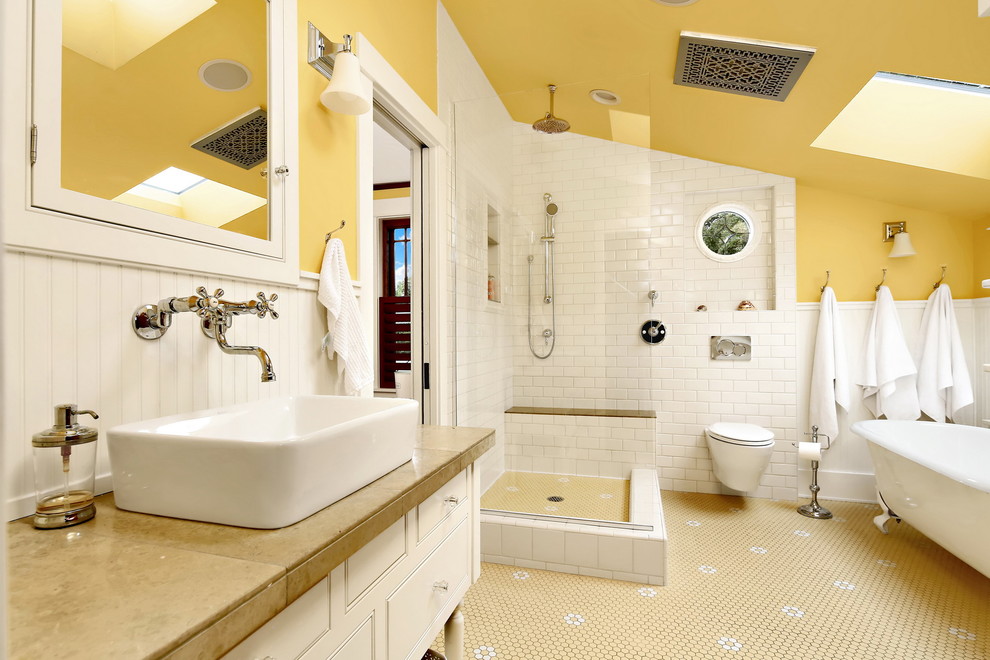 シアトルにある中くらいなヴィクトリアン調のおしゃれなマスターバスルーム (白いキャビネット、猫足バスタブ、オープン型シャワー、壁掛け式トイレ、白いタイル、サブウェイタイル、黄色い壁、合板フローリング、コンソール型シンク、御影石の洗面台、マルチカラーの床、オープンシャワー、ベージュのカウンター) の写真