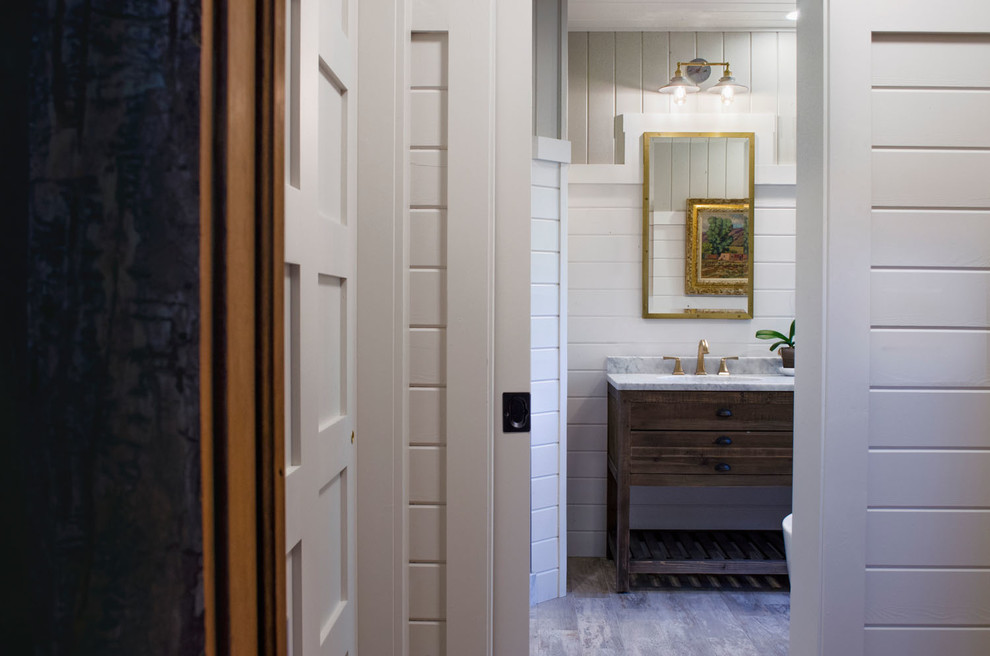 Ispirazione per una grande stanza da bagno padronale country con lavabo integrato, pareti bianche e parquet chiaro