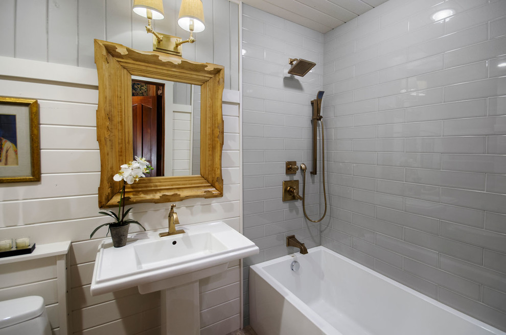 Foto på ett mellanstort lantligt badrum, med ett nedsänkt handfat, ett fristående badkar, en dusch/badkar-kombination, grå kakel, vita väggar och klinkergolv i porslin
