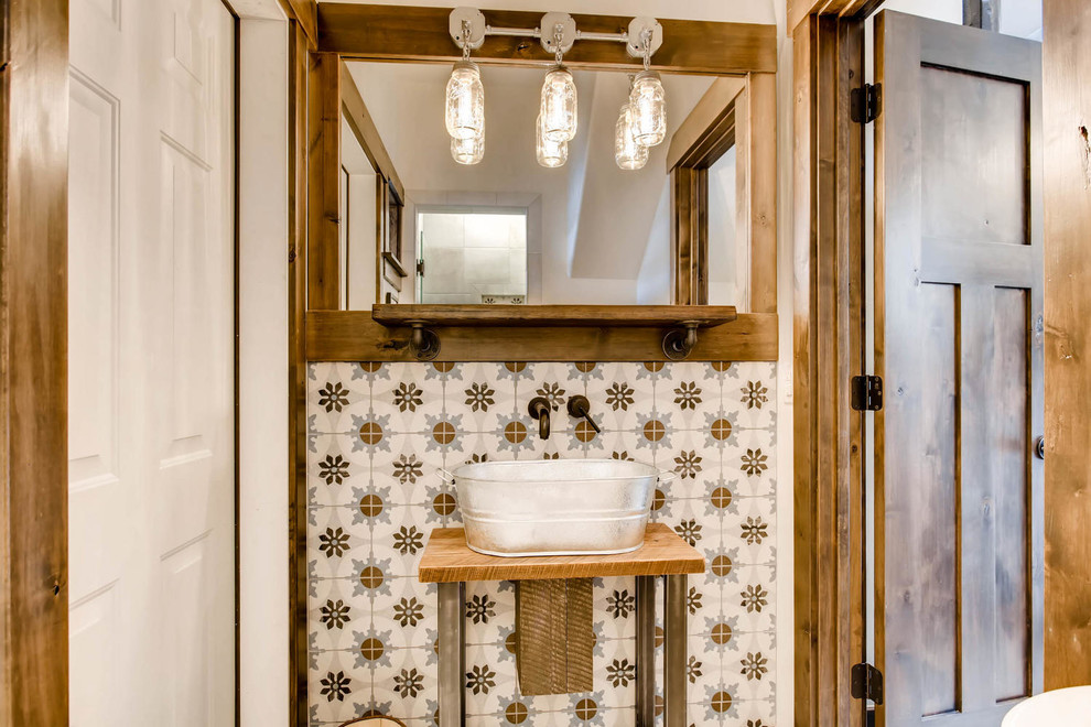 Exemple d'une petite salle d'eau montagne avec un placard sans porte, des portes de placard marrons, un carrelage bleu, des carreaux de porcelaine, une vasque et un plan de toilette en bois.