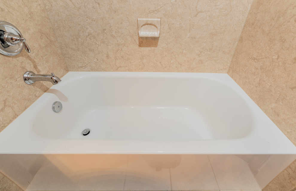 Cette image montre une salle de bain traditionnelle de taille moyenne avec une baignoire en alcôve, un carrelage beige et une cabine de douche avec un rideau.