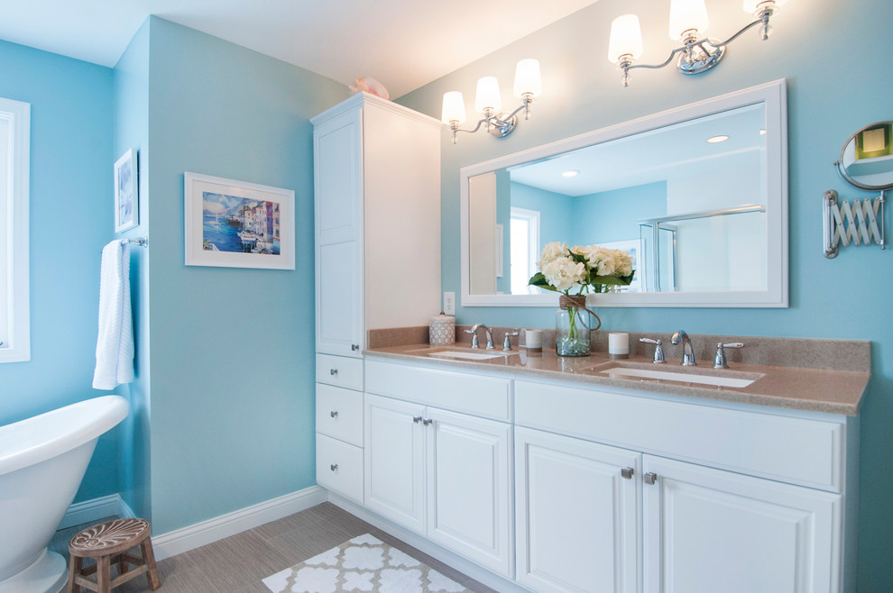 Пример оригинального дизайна: большая главная ванная комната в классическом стиле с фасадами островного типа, белыми фасадами, отдельно стоящей ванной, угловым душем, раздельным унитазом, синими стенами, полом из мозаичной плитки, монолитной раковиной, столешницей из оникса, коричневым полом и душем с распашными дверями