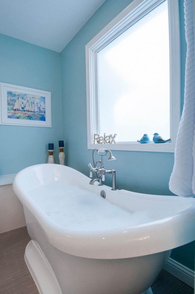 На фото: большая главная ванная комната в морском стиле с белыми фасадами, отдельно стоящей ванной, угловым душем, раздельным унитазом, синими стенами, полом из мозаичной плитки, монолитной раковиной, столешницей из оникса, коричневым полом и душем с распашными дверями