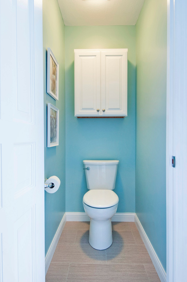 На фото: большой туалет в морском стиле с белыми фасадами, раздельным унитазом, синими стенами, полом из мозаичной плитки, монолитной раковиной, столешницей из оникса и коричневым полом с