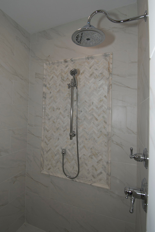 Cette photo montre une salle de bain principale chic avec un plan de toilette en marbre, une douche double et des carreaux de porcelaine.