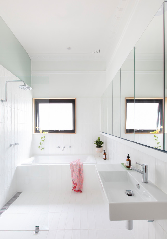 На фото: главная ванная комната в современном стиле с белыми фасадами, накладной ванной, душевой комнатой, белой плиткой, зелеными стенами, подвесной раковиной, белым полом, открытым душем и белой столешницей с