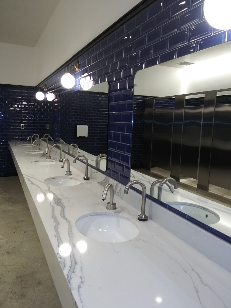 Стильный дизайн: огромная ванная комната в стиле лофт с синей плиткой, белыми стенами, бетонным полом, врезной раковиной, столешницей из искусственного кварца, серым полом и белой столешницей - последний тренд
