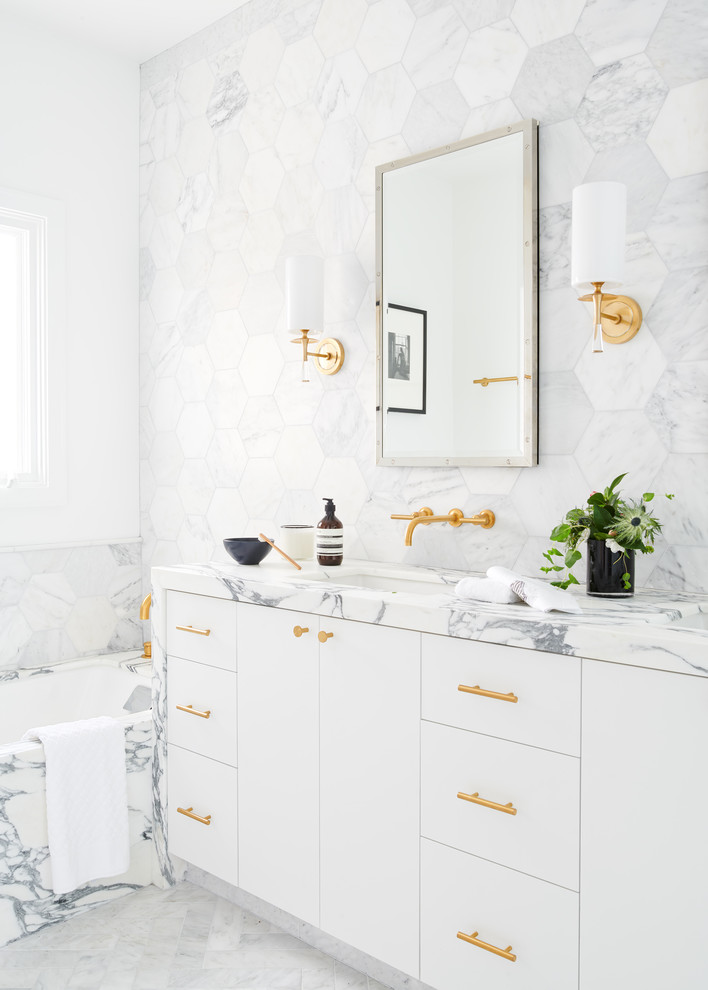 Пример оригинального дизайна: ванная комната в стиле неоклассика (современная классика) с плоскими фасадами, белыми фасадами, полновстраиваемой ванной, белыми стенами, врезной раковиной, белым полом и белой столешницей